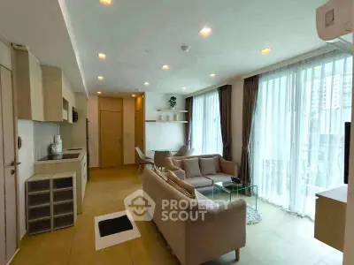Modern living room with open layout, large windows, and stylish furniture in a contemporary apartment.
