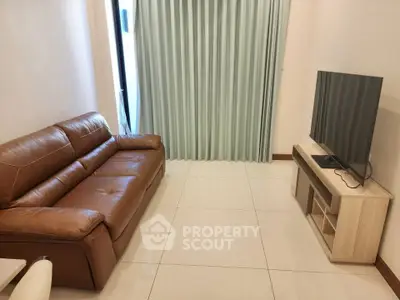 Cozy living room with leather sofa and modern TV setup, perfect for relaxation.