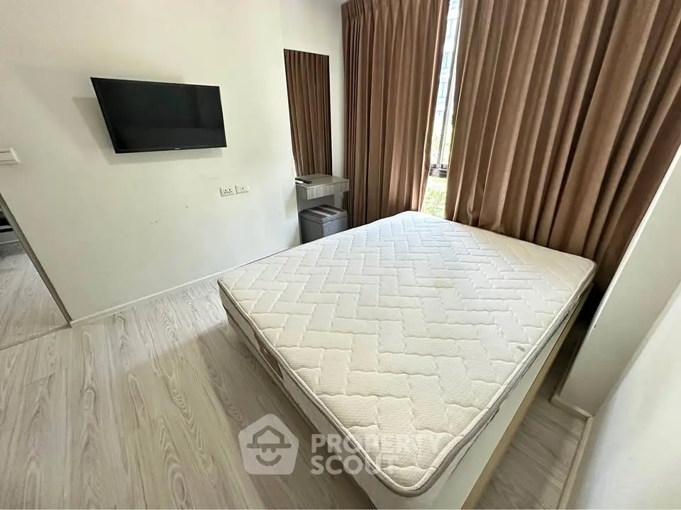 Modern bedroom with minimalist design, featuring a wall-mounted TV and large window with brown curtains.
