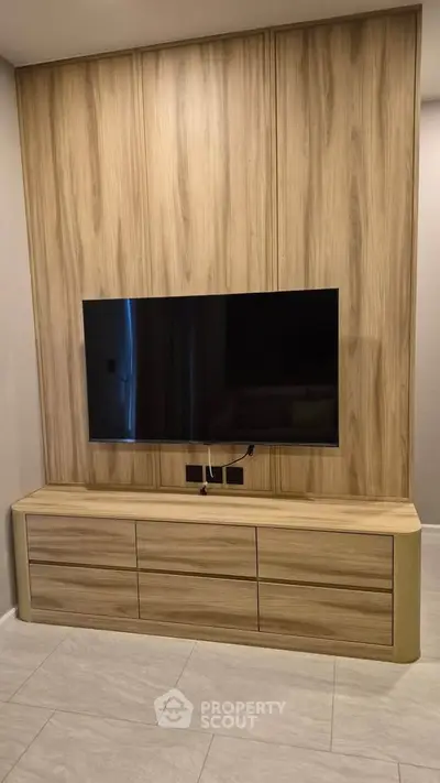 Modern living room with sleek wooden paneling and mounted flat-screen TV