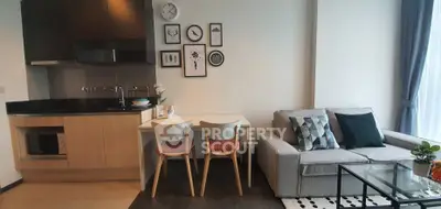 Modern living room with stylish decor and open kitchen layout, featuring cozy seating and elegant dining area.