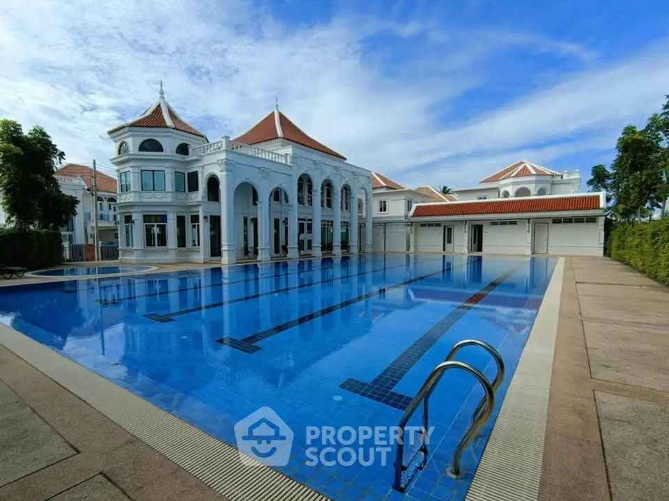 Luxurious villa with expansive pool and elegant architecture under a clear blue sky.