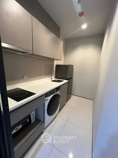 Modern kitchen with sleek cabinetry, integrated appliances, and minimalist design in a compact space.