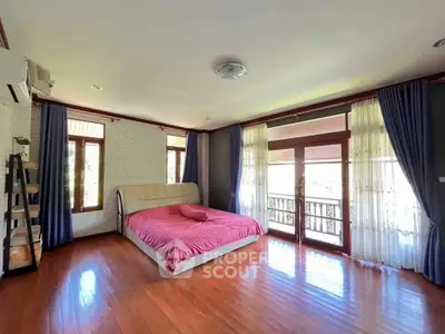 Spacious bedroom with elegant decor and large windows offering natural light and scenic views.