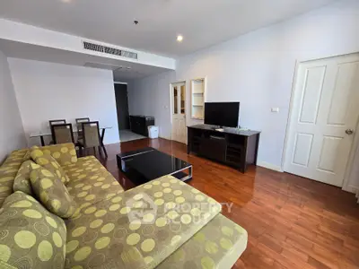 Spacious living room with modern furniture and wooden flooring in a stylish apartment.