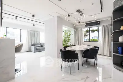 Luxurious open-plan living and dining area with modern decor and large windows.