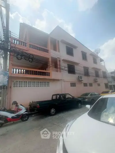 Charming multi-story residential building with balconies and street parking