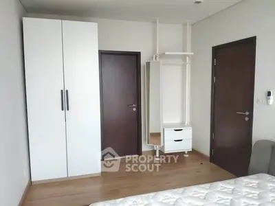 Modern bedroom with minimalist wardrobe and wooden flooring