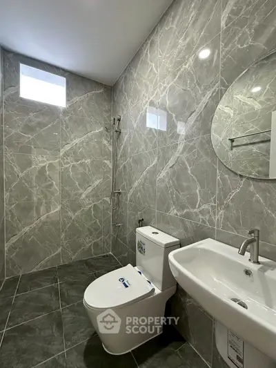 Modern bathroom with sleek marble tiles and contemporary fixtures.