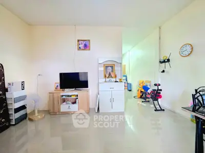 Spacious living area with modern decor and exercise equipment, perfect for a comfortable lifestyle.