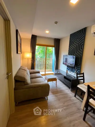 Modern living room with balcony view, stylish decor, and cozy seating in a contemporary apartment.