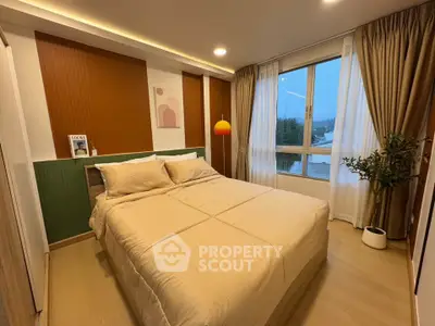 Modern bedroom with cozy lighting and large window offering scenic views.