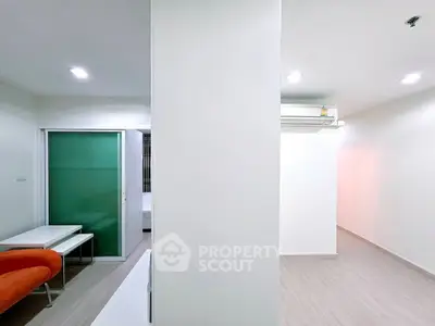 Modern minimalist apartment interior with sleek design and bright lighting, featuring a sliding glass door and air conditioning.
