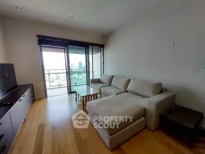 Spacious living room with modern furniture and city view balcony in luxury apartment.
