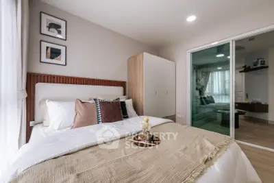 Modern bedroom with cozy decor and sliding glass doors leading to living area.
