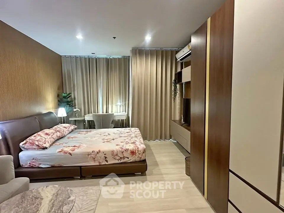 Luxurious bedroom with modern decor and ample natural light, featuring a cozy bed and stylish furnishings.