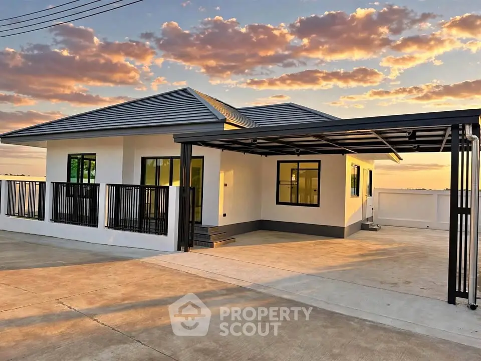 Modern single-story house with sleek design and spacious driveway at sunset.