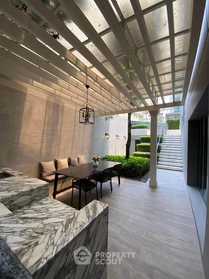 Luxurious outdoor patio with elegant marble countertops and stylish dining area, perfect for entertaining.