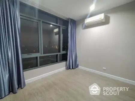 Spacious empty room with large window and air conditioning unit