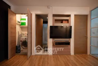 Modern living room with built-in TV unit and hidden laundry area