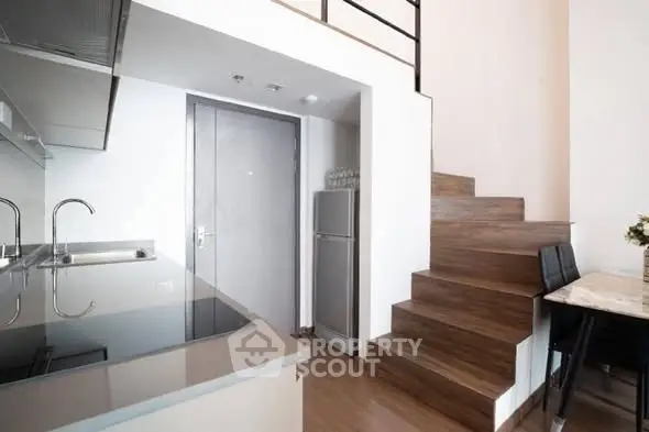 Modern kitchen with sleek design and wooden staircase in stylish apartment