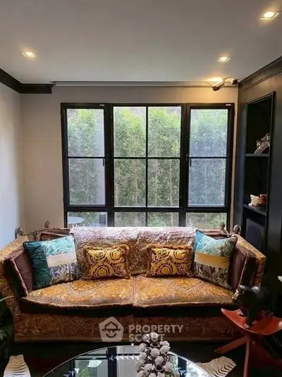 Charming living room with elegant sofa and large windows offering natural light.