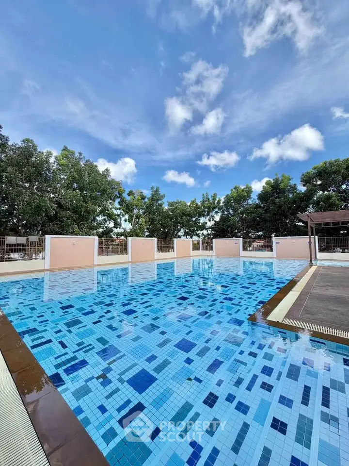 Stunning outdoor pool with vibrant blue tiles and lush greenery, perfect for relaxation and leisure.