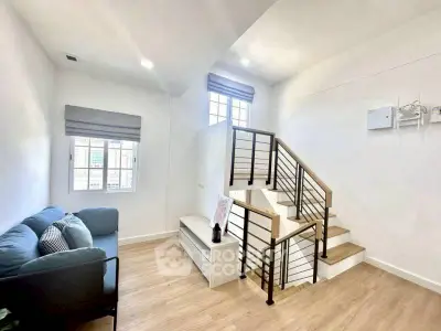 Modern duplex living room with stylish staircase and cozy seating area