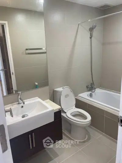 Modern bathroom with sleek fixtures and bathtub in a contemporary apartment.