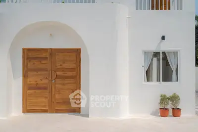 Charming modern white exterior with wooden double doors and potted plants, perfect for a serene home entrance.