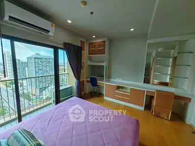 Modern bedroom with city view, featuring built-in desk and large window for natural light.