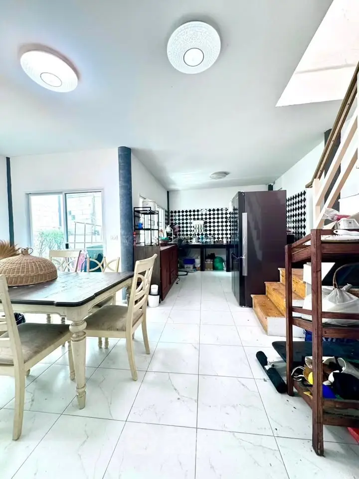 Spacious modern living area with dining set and stylish staircase, perfect for family gatherings.