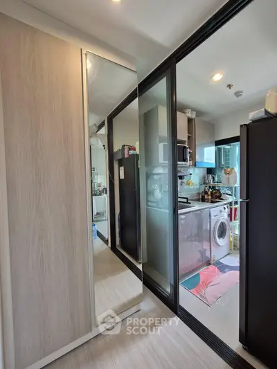 Modern compact kitchen with washing machine and sleek cabinetry in urban apartment
