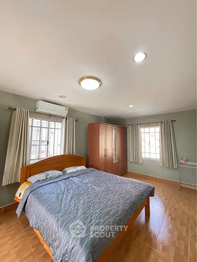 Spacious bedroom with natural light and modern furnishings