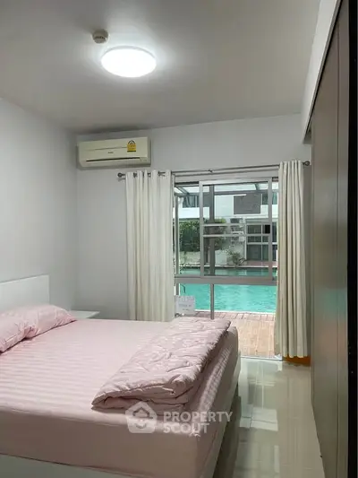 Cozy bedroom with pool view, featuring air conditioning and modern decor.