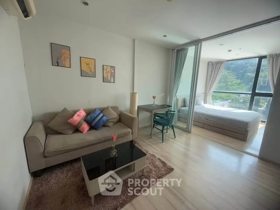 Modern studio apartment with cozy living area and large windows