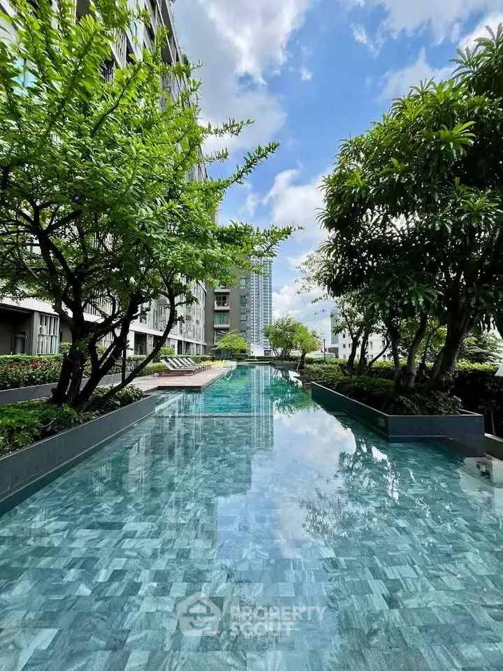 Luxurious residential pool surrounded by lush greenery and modern architecture, offering a serene urban oasis.