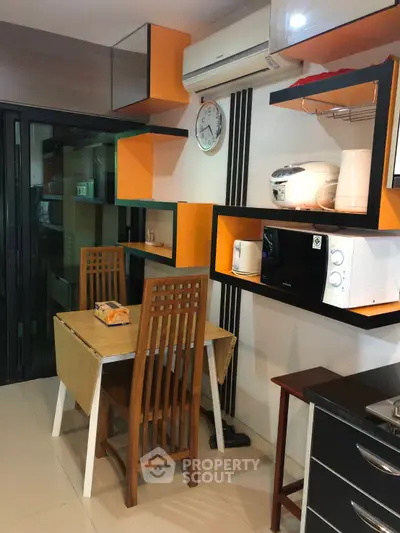 Modern kitchen with vibrant orange shelves and dining area