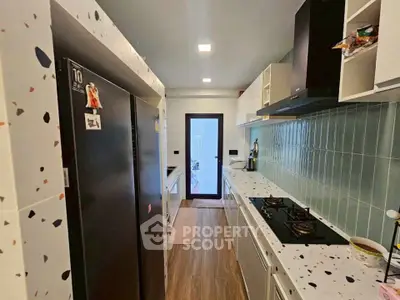 Modern kitchen with terrazzo countertops and gas stove, featuring sleek cabinetry and stylish backsplash.