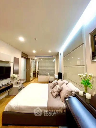 Modern bedroom with elegant decor and ambient lighting in a stylish apartment.