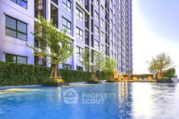 Luxurious high-rise building with serene pool and lush greenery