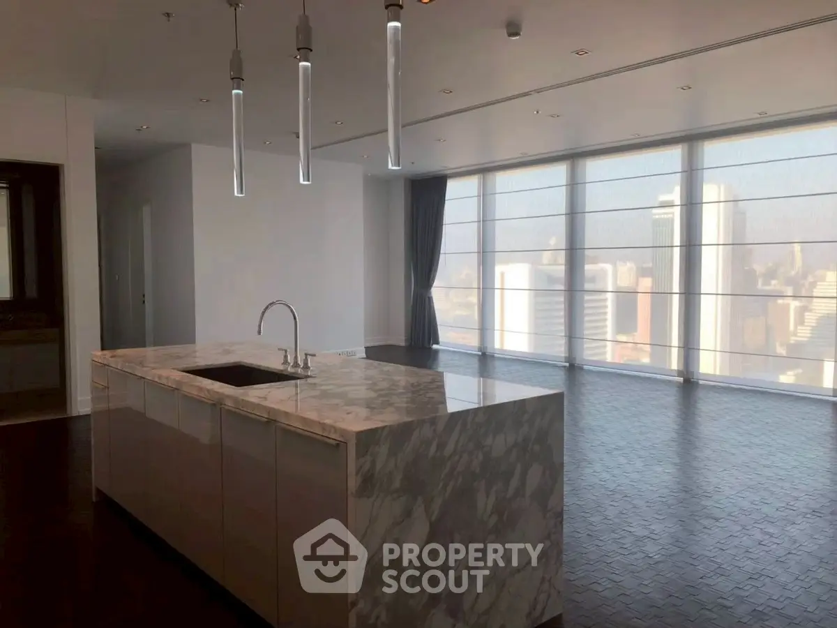 Luxurious open-plan living room with marble kitchen island and stunning city view.