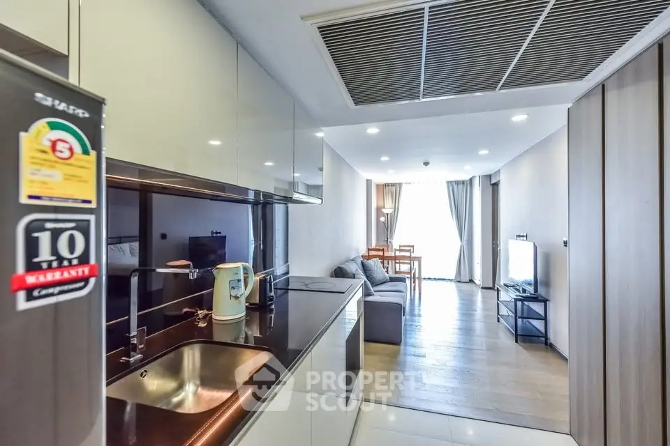 Modern open-layout kitchen and living room with sleek design and natural light.