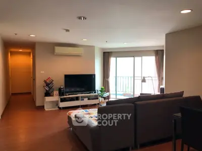 Spacious living room with modern decor and balcony access