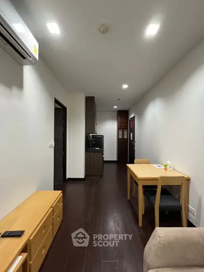 Modern apartment interior with sleek wooden flooring and minimalist furniture.