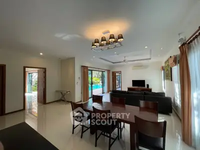Spacious living room with pool view and elegant dining area