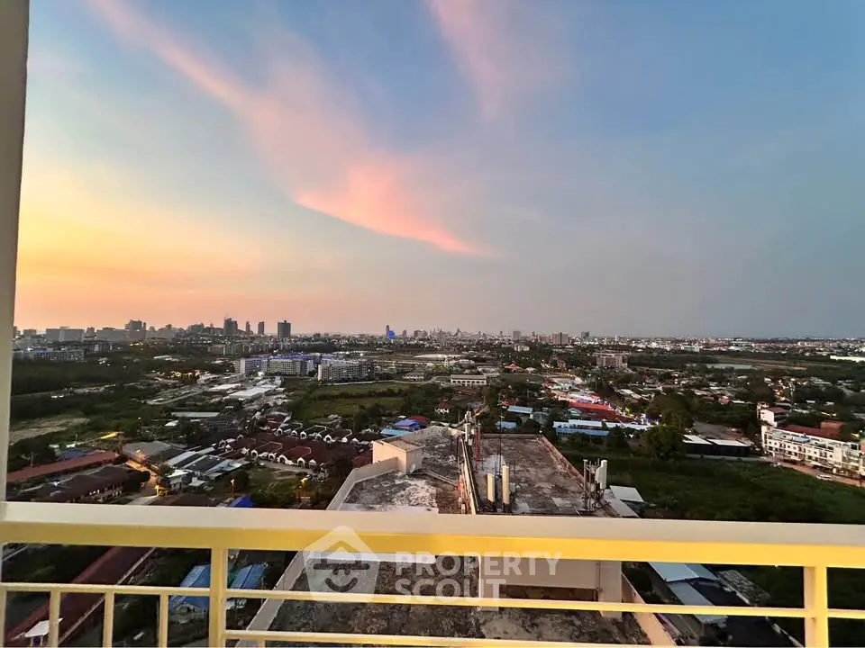Stunning cityscape view from a high-rise balcony at sunset, showcasing urban skyline and vibrant sky.