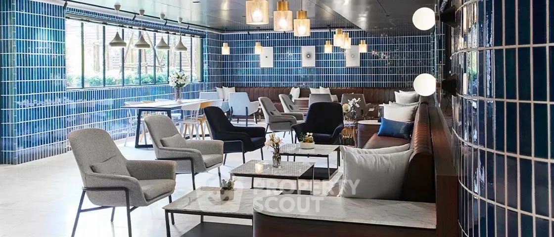 Stylish modern lounge with blue tiled walls and elegant seating in a luxurious building.