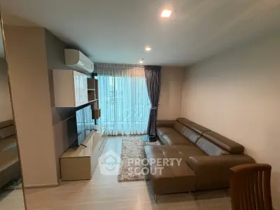 Modern living room with sleek leather sofa and large TV, featuring elegant curtains and ambient lighting.