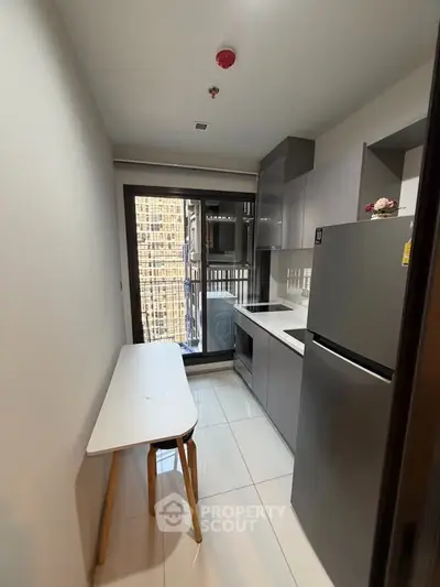 Modern compact kitchen with sleek cabinetry and balcony view